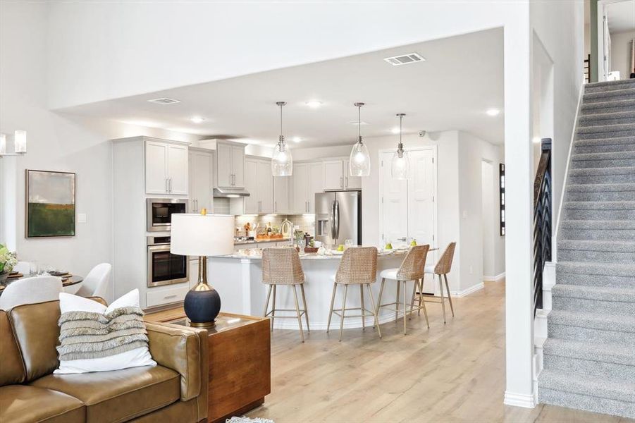 Living room with light wood-type flooring and recessed lighting