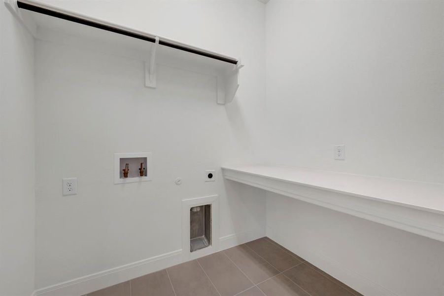 Laundry area featuring gas dryer hookup, dark tile patterned floors, hookup for a washing machine, and electric dryer hookup