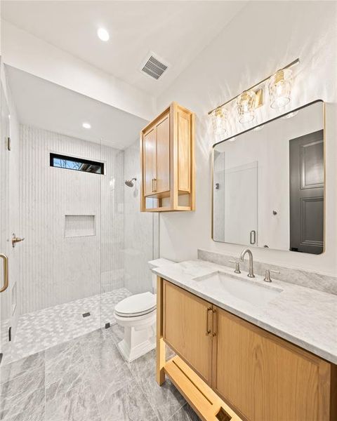 Bathroom with vanity, a shower stall, recessed lighting, and light marble finish floors