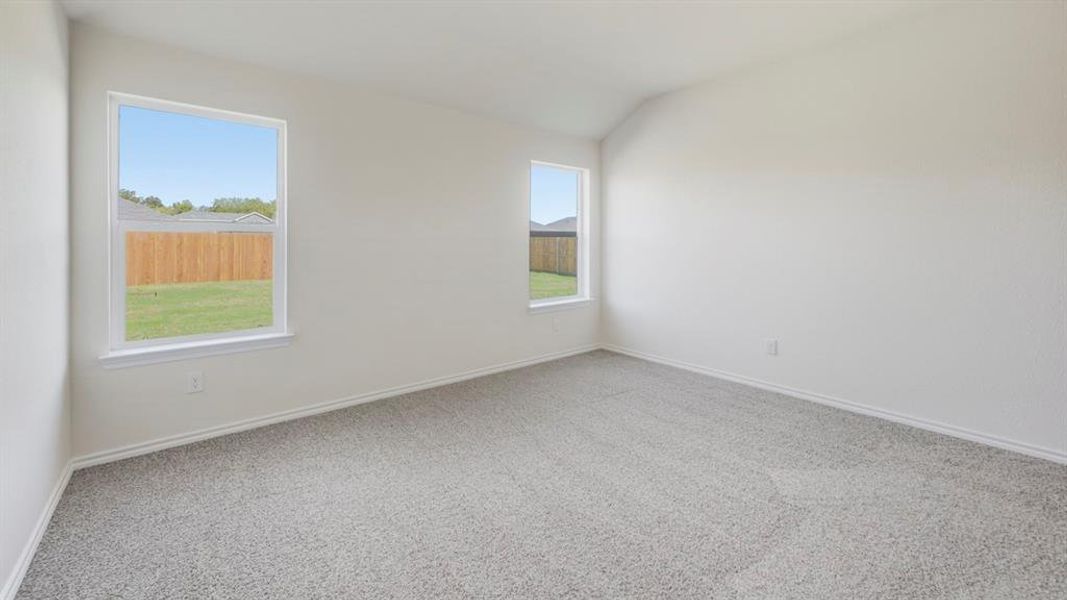 Empty room with light carpet and vaulted ceiling