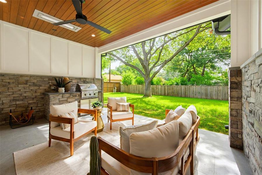 Covered patio with a wood-finish ceiling, integrated lighting, and ceiling fan
