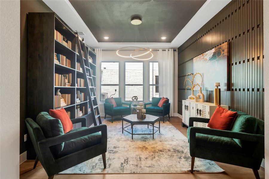 Living area featuring a tray ceiling, wood finished floors, recessed lighting, and a chandelier Living area featuring a tray ceiling, wood finished floors, recessed lighting, and a chandelier