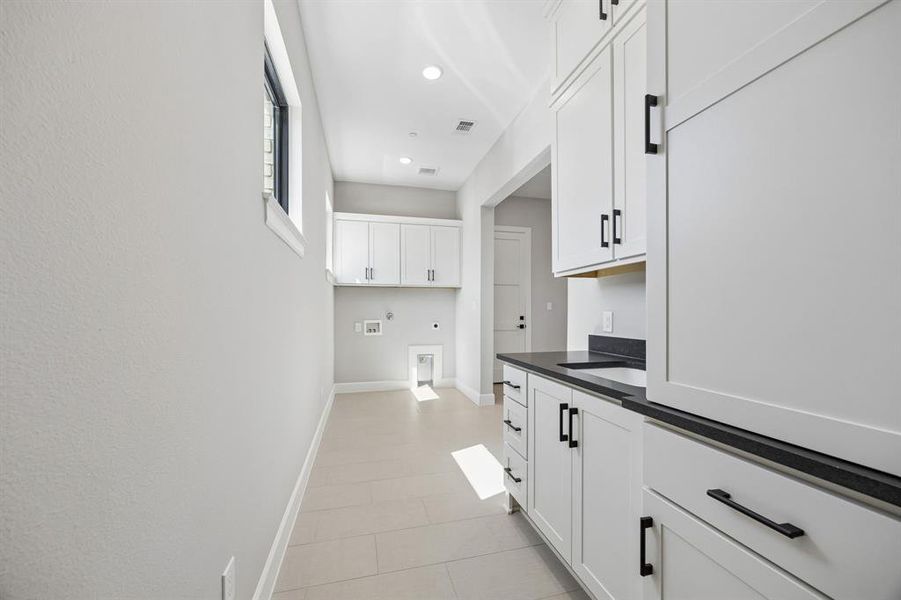 Laundry area with cabinet space, washer hookup, electric dryer hookup, gas dryer hookup, and recessed lighting Laundry area with cabinet space, washer hookup, electric dryer hookup, gas dryer hookup, and recessed lighting