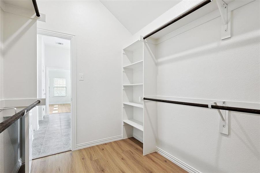 Walk in closet featuring vaulted ceiling and light tile flooring