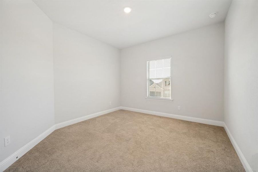 Carpeted room with white walls, a single window with blinds, and white baseboards