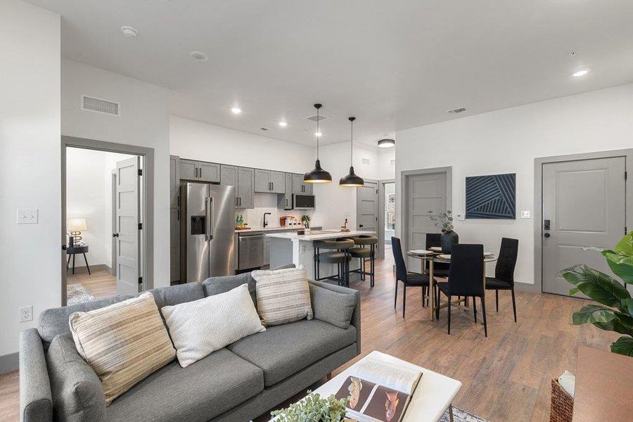 Living room with light wood-type flooring and recessed lighting