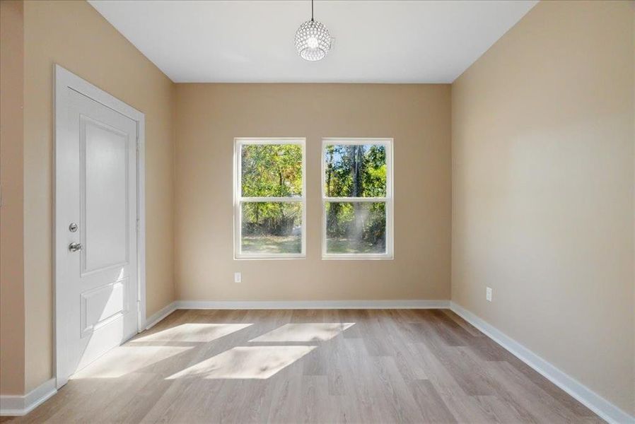 Empty room with light hardwood / wood-style flooring