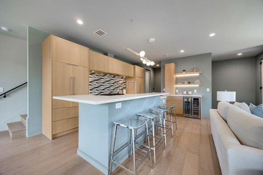 The open-concept kitchen includes custom cabinetry, paneled Fisher Paykel refigerator /freezer that blend in seamlessly. White quartz is found on the island and separate bar. Easily seat 4 at the raised island where you can eat, enjoy a meal or just hang out with the cook.