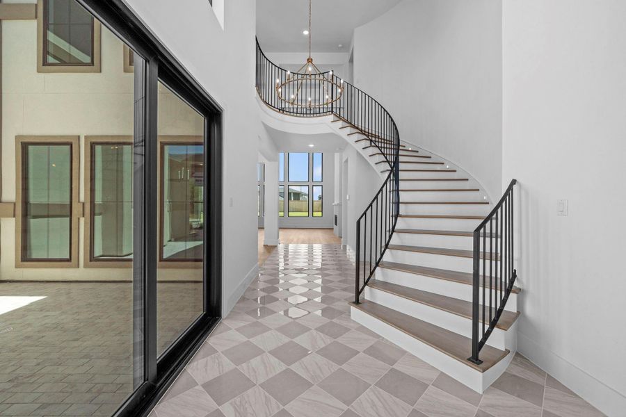 Beautiful courtyard entry showcasing the home's curved grand staircase and architectural details.