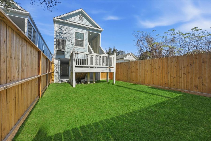 Another view of the yard highlights the generous lot size and privacy fencing, reinforcing the home’s outdoor living potential.