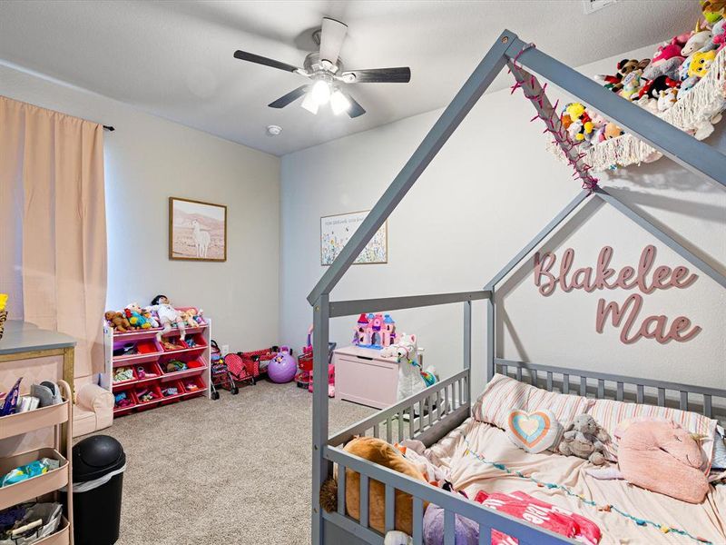 Carpeted bedroom featuring ceiling fan