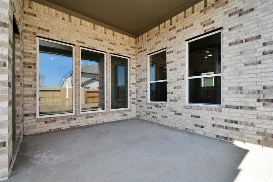 Experience outdoor living at its finest on this expansive covered patio, thoughtfully designed for BBQs and delightful outdoor dining. Sample photo of completed home with similar plan. As built color and selections will vary.