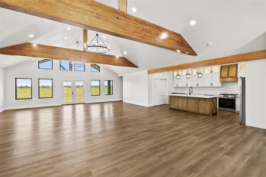 The open-concept living, dining, and kitchen areas are designed to take advantage of the home's unobstructed views. Vaulted ceilings, exposed beams, and modern lighting create a bright and inviting atmosphere.