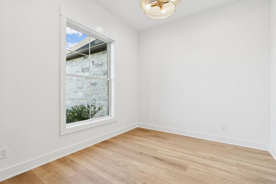 Dedicated office at the front of the home with another gorgeous light fixture.