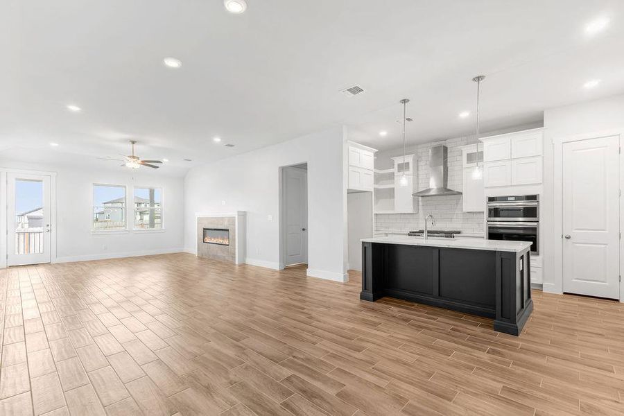 An open-concept living space with a contemporary kitchen island and a cozy fireplace. An open-concept living space with a contemporary kitchen island and a cozy fireplace.
