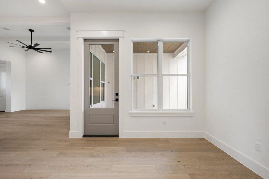 This bright interior features light-toned wood flooring, crisp white walls, and a recessed light fixture