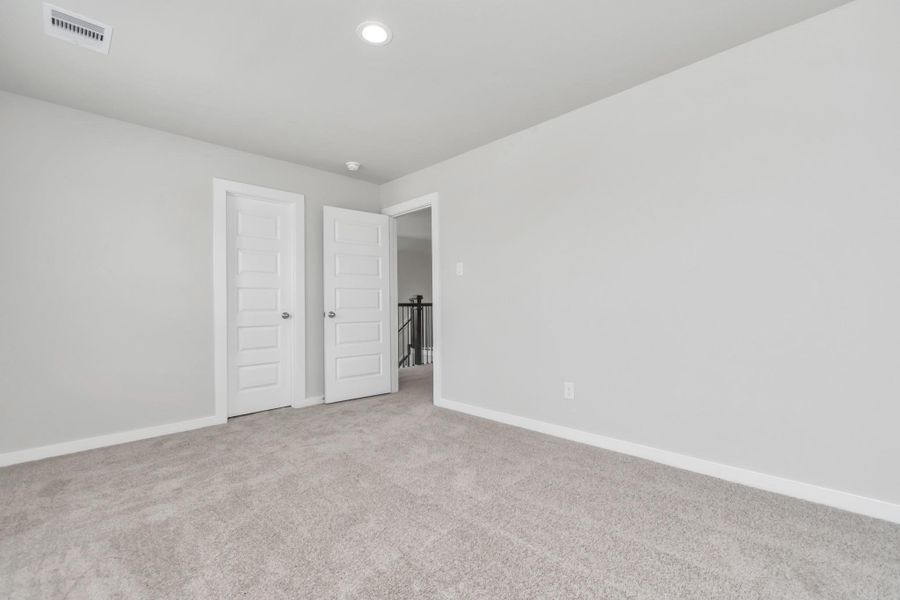 Generously sized secondary bedrooms featuring spacious closets, soft and inviting carpeting underfoot, large windows allowing plenty of natural light, and the added touch of privacy blinds for your personal retreat. Sample photo of completed home with similar floor plan. Actual colors and selections may vary.