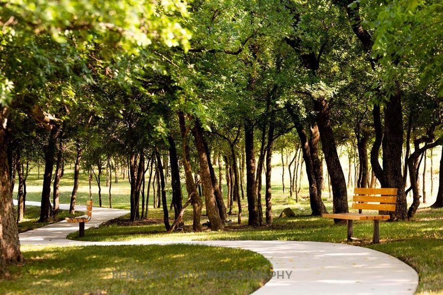 View of community featuring a yard and view of scattered trees View of community featuring a yard and view of scattered trees