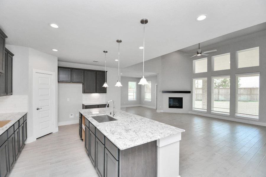 This kitchen is by far any chef’s dream! This spacious kitchen features high ceilings, light stained wood cabinets, granite countertop, SS appliances, modern tile backsplash, recessed lighting, extended counter space, granite kitchen island, and space for breakfast bar, and a walk-in pantry all overlooking your huge family room. Sample photo of completed home with similar floor plan. Actual colors and selections may vary.