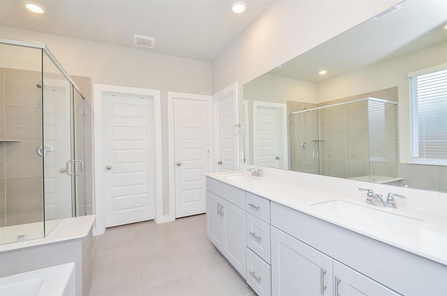 Primary bath offers double sinks and extra storage.