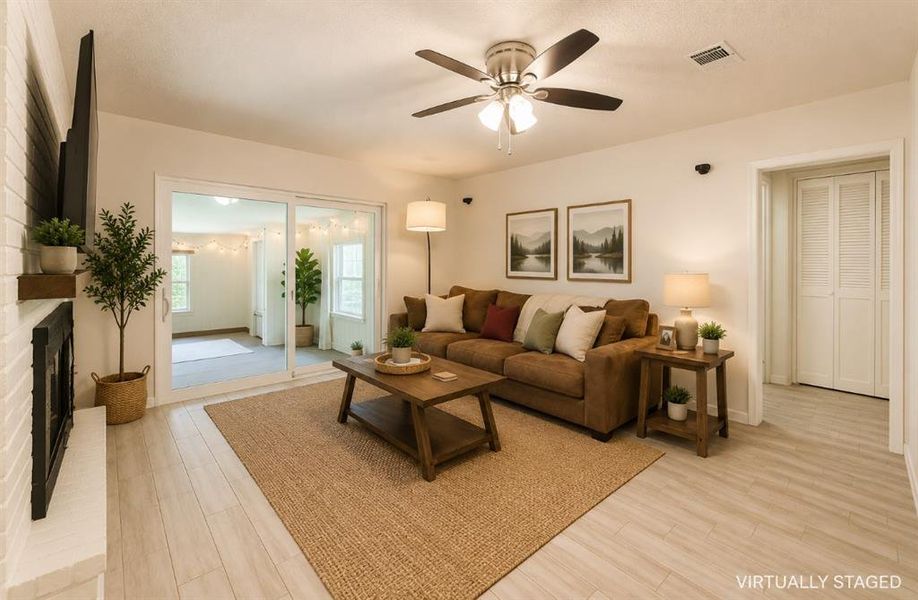 Living area featuring light wood-finish flooring and a ceiling fan