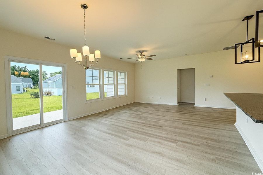 Unfurnished dining area featuring a chandelier, light wood-type flooring, and ceiling fan Unfurnished dining area featuring a chandelier, light wood-type flooring, and ceiling fan