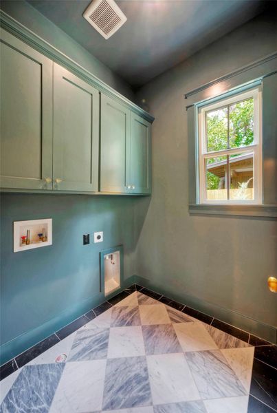A well-appointed laundry space features checkerboard marble flooring and ample cabinetry for storage.