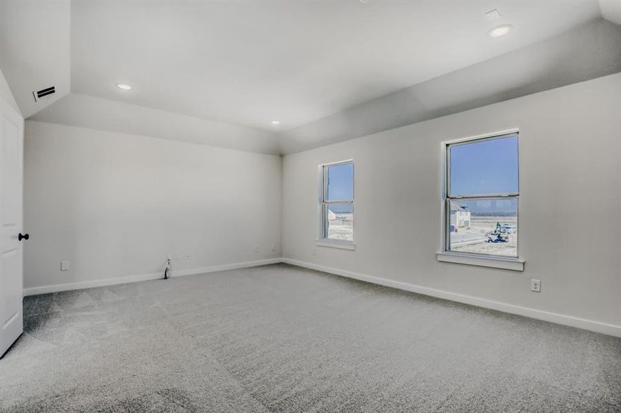 Spare room with lofted ceiling, light carpet, and recessed lighting
