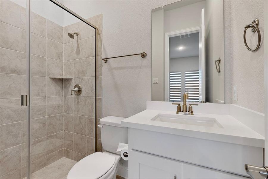 Bathroom featuring vanity, a stall shower, and a textured wall