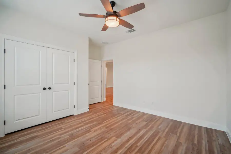 Bedroom 2 featuring a closet, baseboards, visible vents, and light wood finished floors