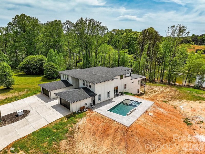 Aerial view of the property showcasing its prime location on a peaceful cove just off Lake Norman with expansive surrounding land.