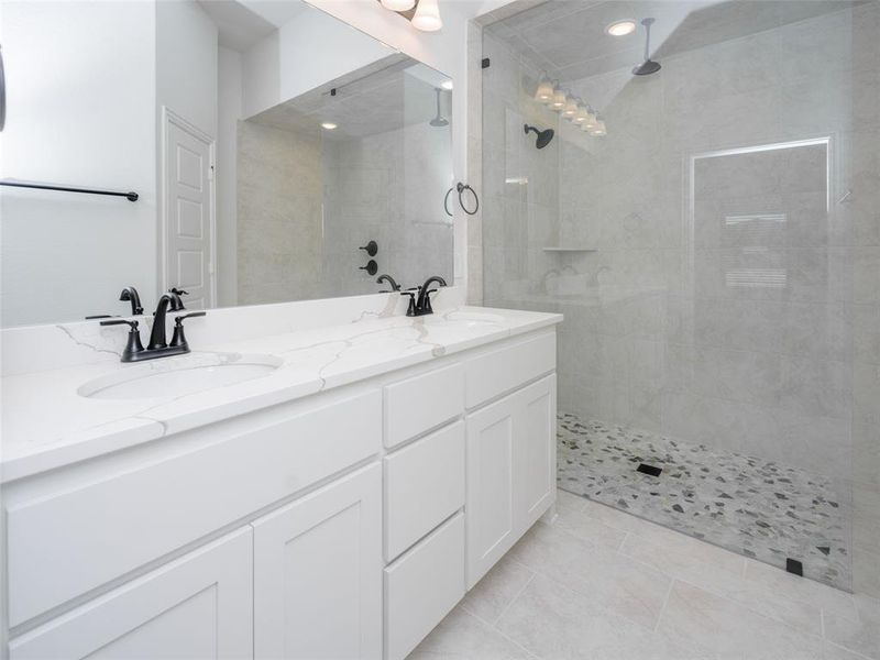 Full bathroom featuring double vanity, a walk in shower, and light tile patterned flooring Full bathroom featuring double vanity, a walk in shower, and light tile patterned flooring