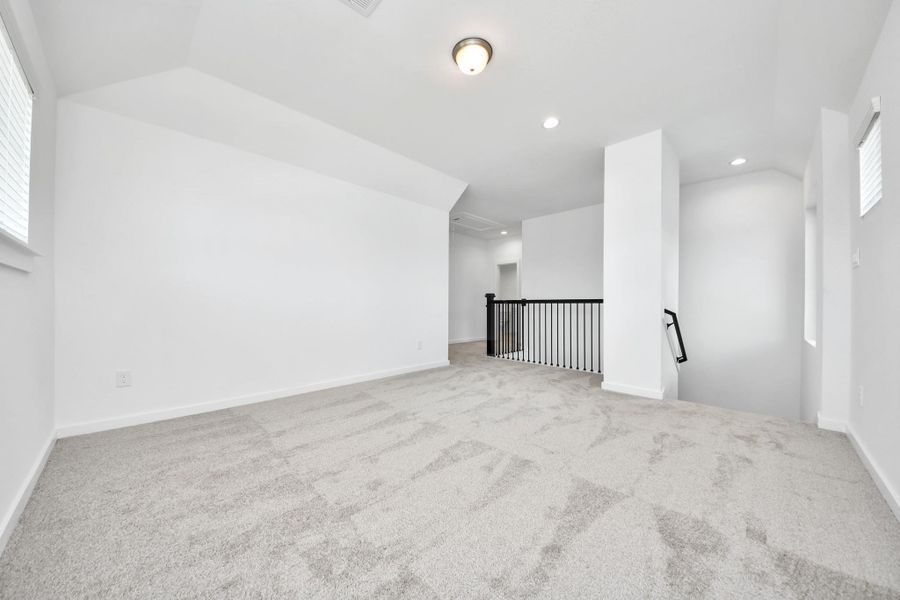 Ascend to relaxation in this fantastic game room! Ideal for both casual gatherings and adult gaming, it boasts plush carpet, lofty ceilings, custom paint, and ample windows for abundant natural light.