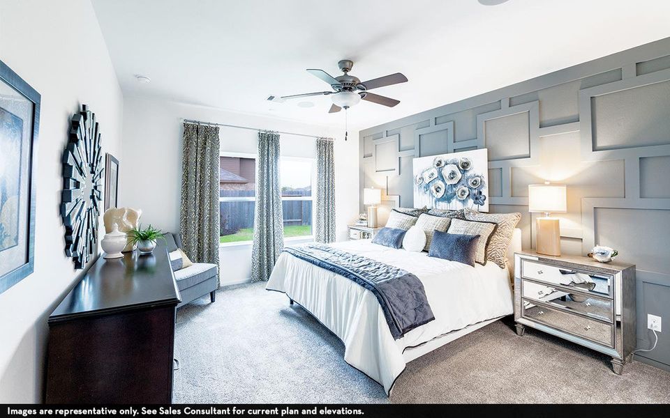 Bedroom with a decorative wall, carpet floors, and a ceiling fan