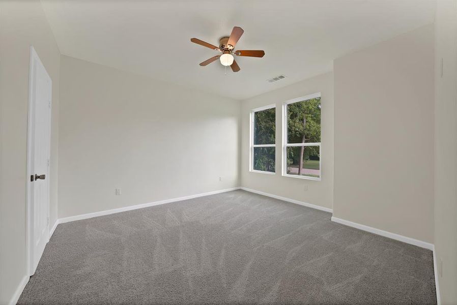 Spare room with dark carpet and ceiling fan