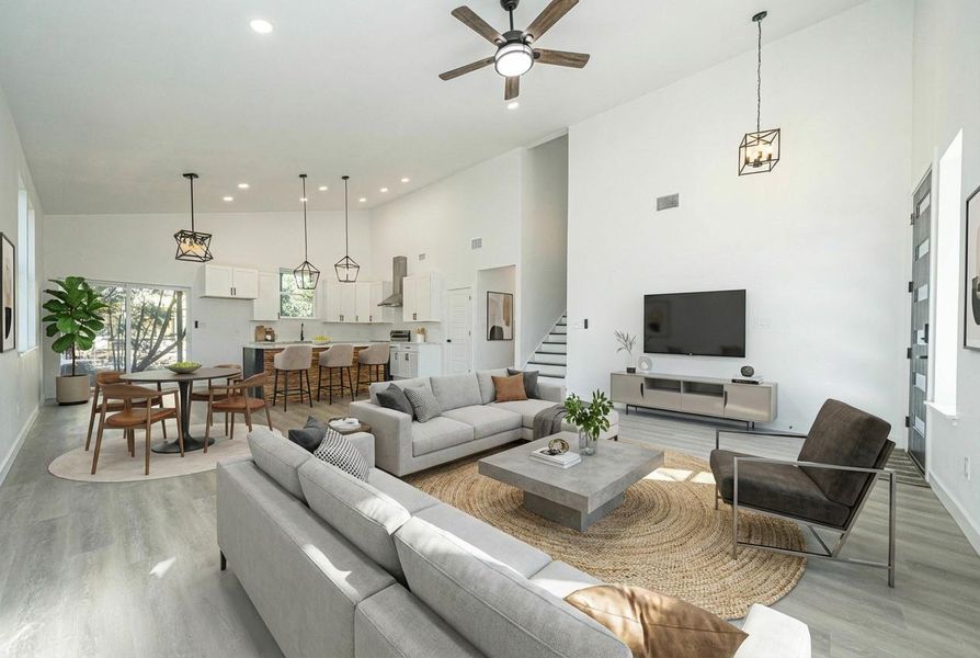 Living room featuring stairs, high vaulted ceiling, light wood finished floors, a ceiling fan, and recessed lighting