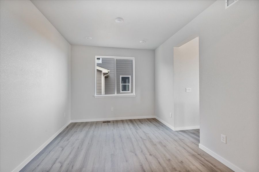 A room with a wood floor and a window. A room with a wood floor and a window.