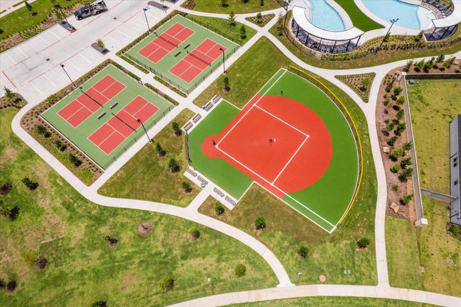 Community tennis courts and open kickball/baseball field for outdoor recreation.