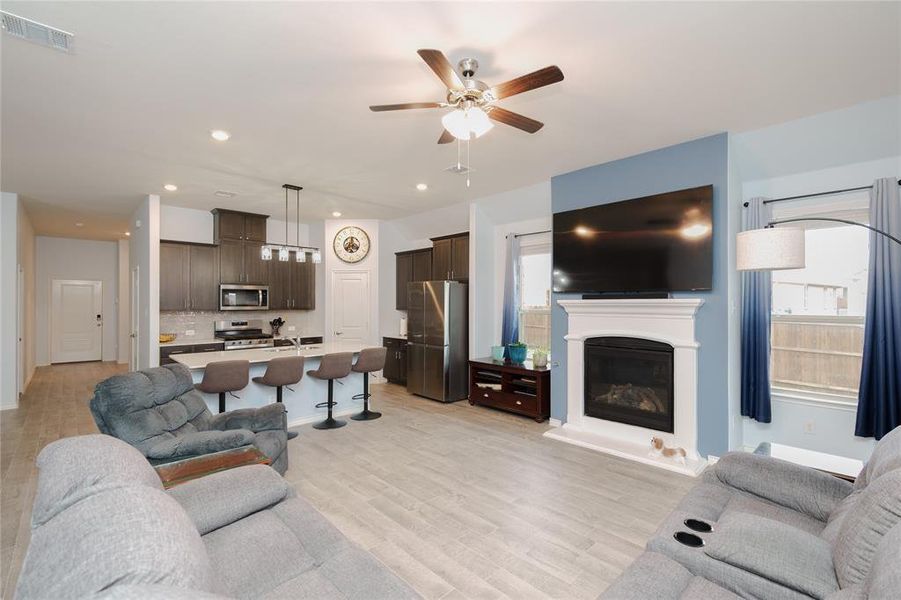 Living room with ceiling fan and light hardwood / wood-style flooring