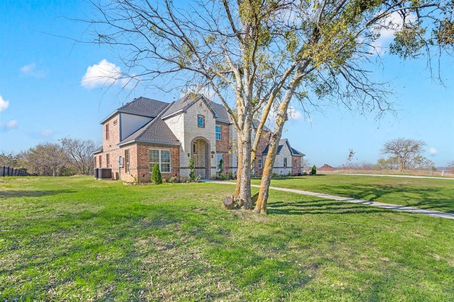View of front of property with a front yard, brick siding, and roof with shingles View of front of property with a front yard, brick siding, and roof with shingles