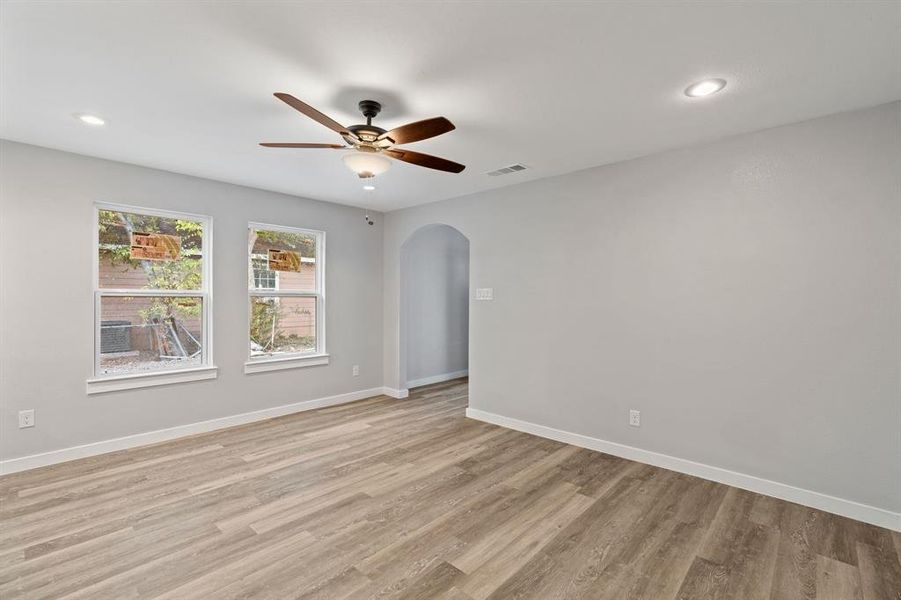 Empty room with ceiling fan and light hardwood / wood-style flooring