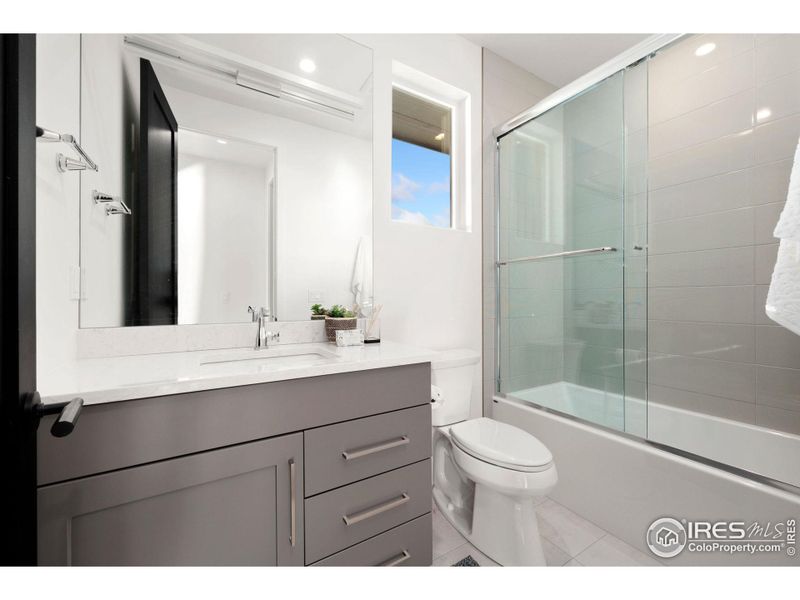 Upstairs Bedroom 1 Ensuite Bathroom with Bathtub & Glass Sliding Closure