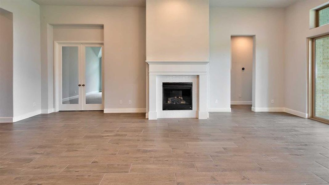 Unfurnished living room featuring french doors and light tile patterned floors