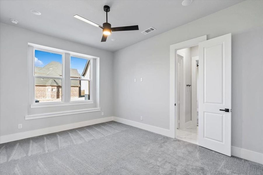 Carpeted spare room with ceiling fan