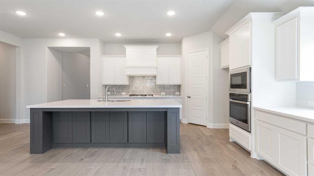 Kitchen featuring white cabinets, stainless steel appliances, light hardwood / wood-style floors, and sink