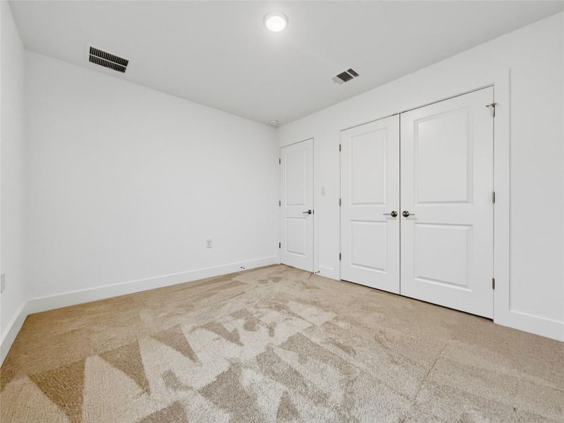 Bedroom featuring light carpet and baseboards