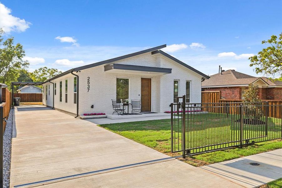 Front View of Home  Featuring Extensive Driveway & Sliding Iron Gate.