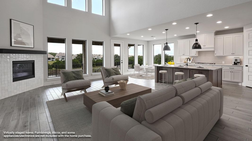 Living area with wood finished floors, a high ceiling, recessed lighting, and a tile fireplace Living area with wood finished floors, a high ceiling, recessed lighting, and a tile fireplace