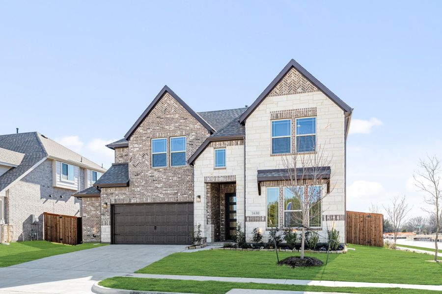 Two-story home with brick and stone exterior, two-car garage, and manicured front lawn Two-story home with brick and stone exterior, two-car garage, and manicured front lawn
