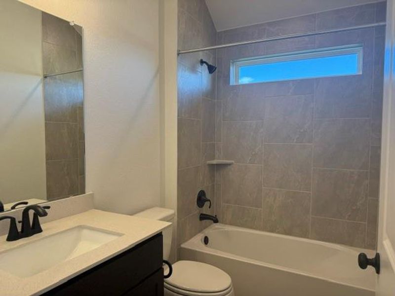 Bathroom with full-height subway tile shower surround, integrated soap niche, and a horizontal window
